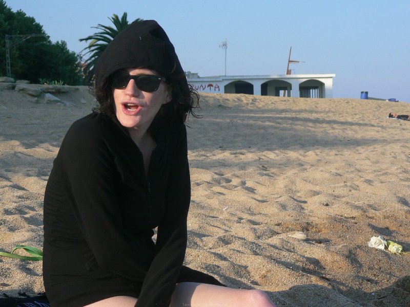 Прохожий фотографирует на пляже загорающих без одежды туристок