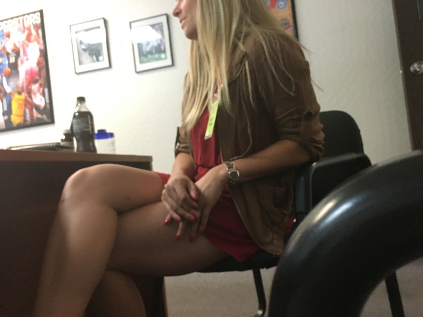 Модель со свелыми волосами в офисе в короткой юбочке